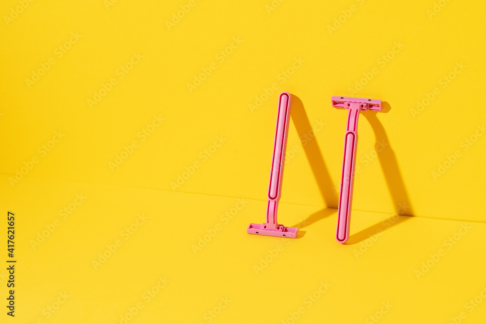 Studio shot of disposable razor tools on yellow Studio shot of disposable razor tools on yellow