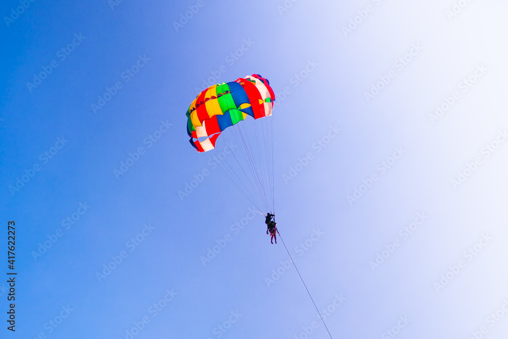 Parasailing in blue sky. Sports, active leisure, travel, vacation concept Parasailing in blue sky. Sports, active leisure, travel, vacation concept