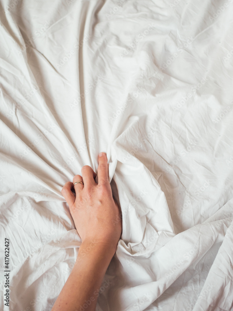 Woman's hand on background of crumpled bed sheet. Creased unmade bed. Woman  squeezes white linen. Cozy imperfect house. Non-ideal cozy home. Stock  Photo | Adobe Stock