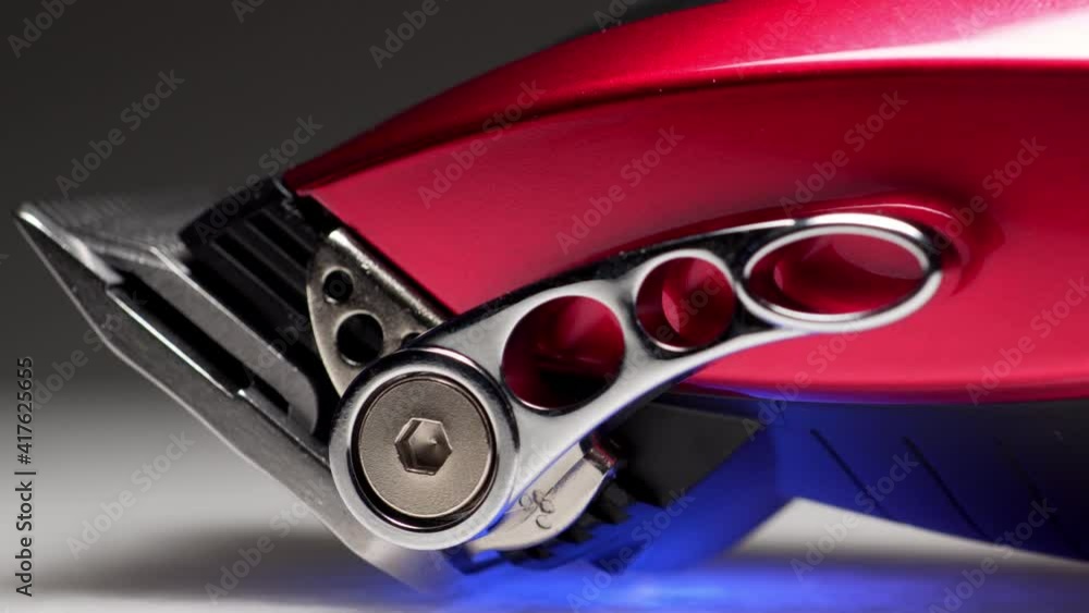 A rotating close up macro clip of barbers red professional quality hair clippers in slow motion shot in 4k A rotating close up macro clip of barbers red professional quality hair clippers in slow motion shot in 4k