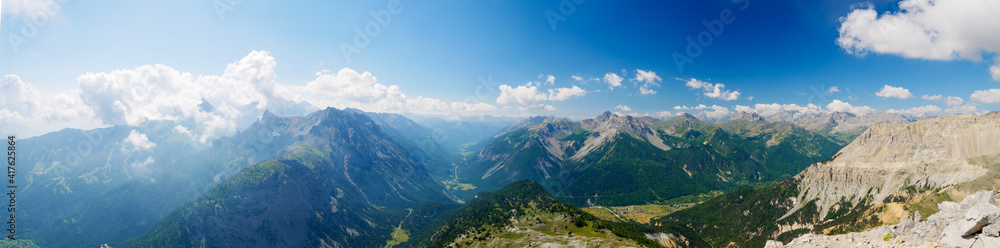 High altitude landscape in idyllic uncontaminated environment once covered by glaciers. Summer adventures and exploration on the Italian French Alps. Expansive view from above, clear blue sky.
