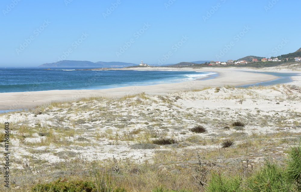 Beach with lighthouse, sand dunes and waves at Rias Baixas region. Lariño, Carnota, Coruña, Galicia, Spain.