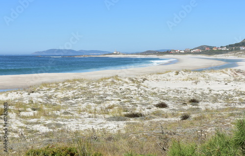 Fototapeta Naklejka Na Ścianę i Meble -  Beach with lighthouse, sand dunes and waves at Rias Baixas region. Lariño, Carnota, Coruña, Galicia, Spain.