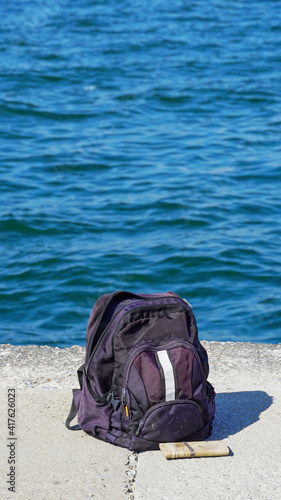 A backpack is on the pier of a seaside © İdil Toffolo