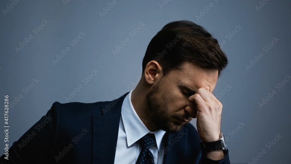 Tired businessman with hand near eyes isolated on grey Tired businessman with hand near eyes isolated on grey