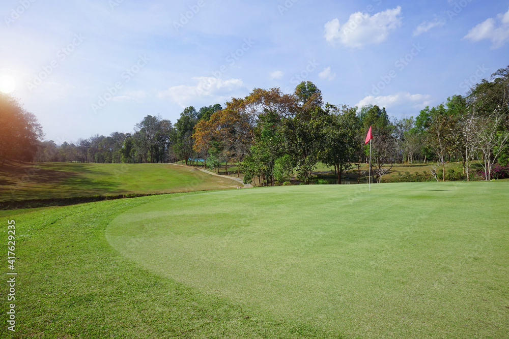 Background of evening golf course has sunlight shining down at golf course in Thailand. Nice scenery on a golf course at a late summer afternoon. Background of evening golf course has sunlight shining down at golf course in Thailand. Nice scenery on a golf course at a late summer afternoon.