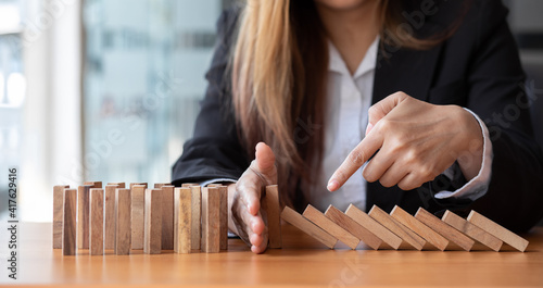  Businesswoman protect wooden block fall to planning and strategy in risk to business Alternative and prevent. Investment Insurance ,Business risk control concept,