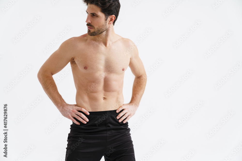 Shirtless athletic sportsman posing and looking aside