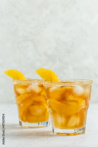 Tropical orange iced tea, summer party drink in glasses. Space for text.