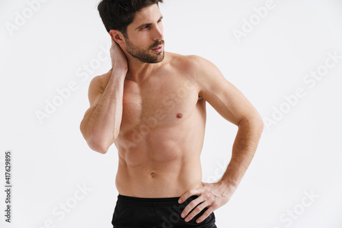 Shirtless athletic sportsman posing and looking aside