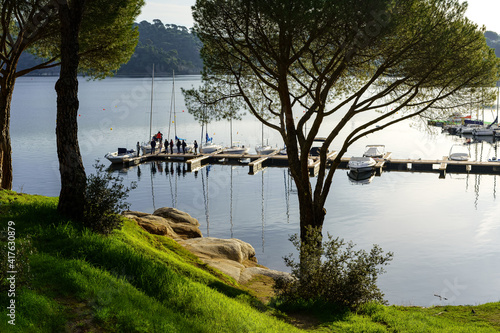 People learning to sail on a sailing boat with a teacher teaching the lesson in the San Juan reservoir in Madrid. photo