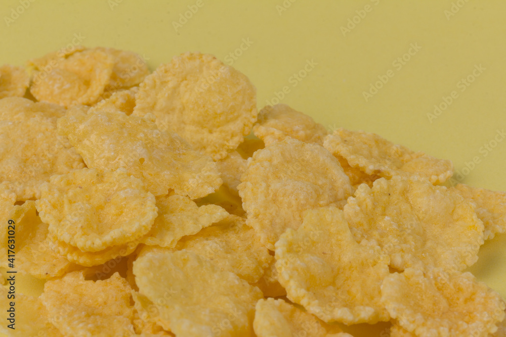 Pile of yellow cornflakes on yellow background Pile of yellow cornflakes on yellow background