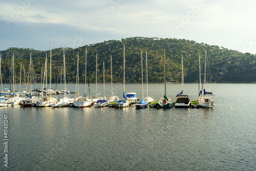 Sailing and motor boats moored at the docks of the San Juan reservoir in Madrid, sunset and an atmosphere of peace and tranquility.