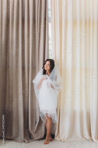 gorgeous happy luxury stylish brunette bride near a window on the background of vintage room