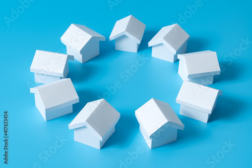 3D white houses model in circle on blue background for real estate property, housing development or community