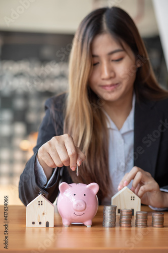 Save money, Female hand putting a coin into piggy bank.saving the money for home concept 