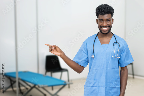 Pointing african male nurse at vaccination station