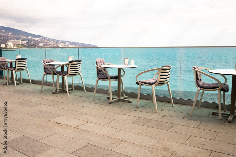 Empty outdoor cafe on the seafront promenade.