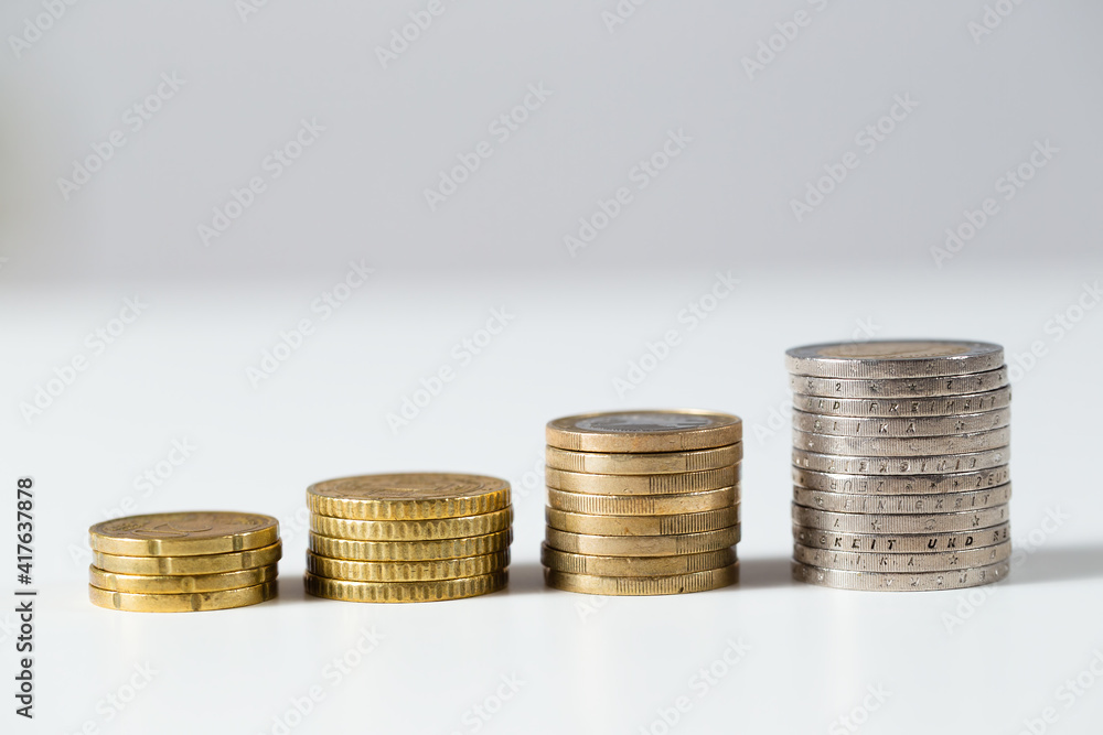 Pile of euro coins prospering on white background. Golden money cash growing in steps. Concept of investment increasing value over time from close-up. Pile of euro coins prospering on white background. Golden money cash growing in steps. Concept of investment increasing value over time from close-up.