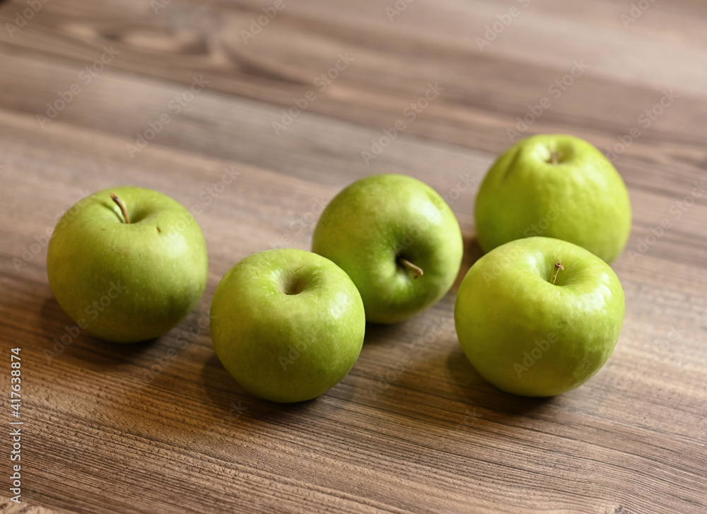 Green apples on a wooden table. Image with selective focus. Green apples on a wooden table. Image with selective focus.