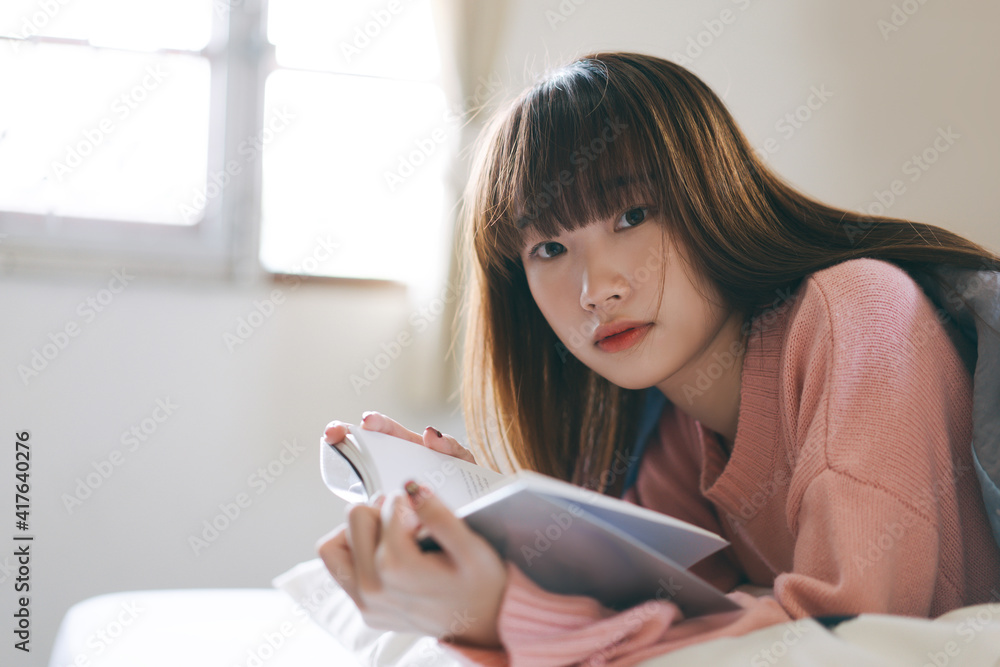 Portrait young asian cute woman teen college student reading a book at bedroom on morning. Portrait young asian cute woman teen college student reading a book at bedroom on morning.
