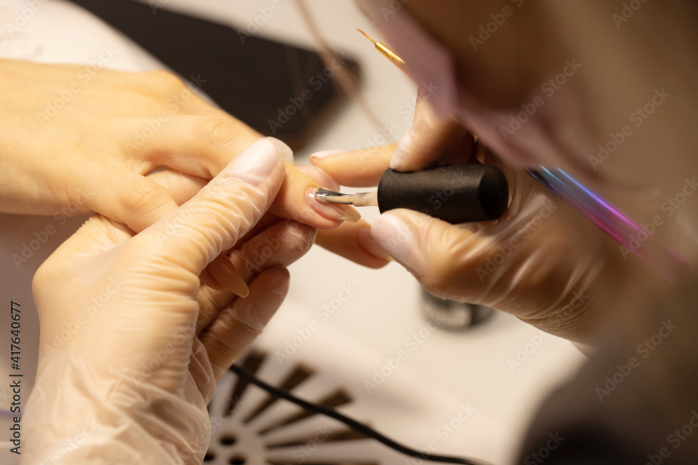 Obraz premium Nail polish woman to a beautician.Treatment hand and nail care the woman to a beautician for a manicure. Selective focus.