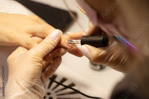 Nail polish woman to a beautician.Treatment hand and nail care the woman to a beautician for a manicure. Selective focus.