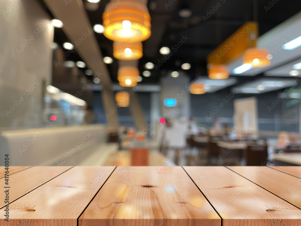 Empty wooden table top with lights bokeh on blur restaurant background. Empty wooden table top with lights bokeh on blur restaurant background.