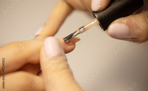 Nail polish woman to a beautician.Treatment hand and nail care the woman to a beautician for a manicure. Selective focus.