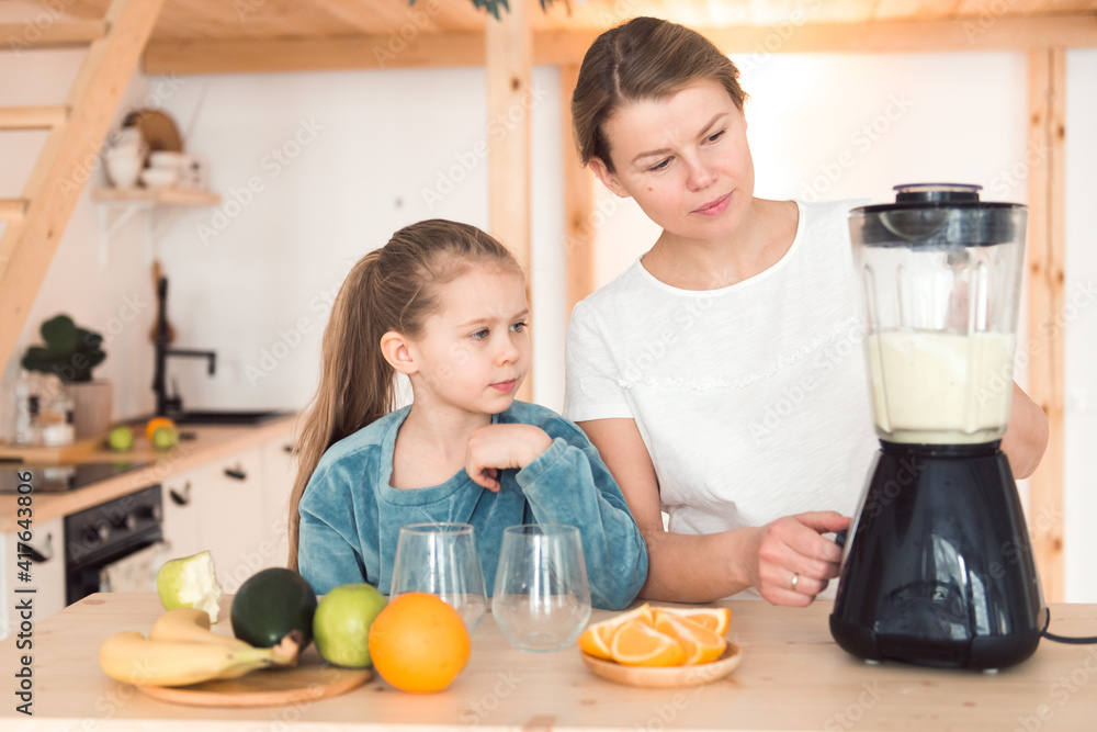 Mom and daughter make fresh smoothie in blender, healthy food lifestyle Mom and daughter make fresh smoothie in blender, healthy food lifestyle