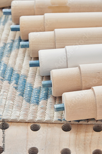 Lathe wooden legs of solid birch with built-in screw pin folded in a row on workbench closeup