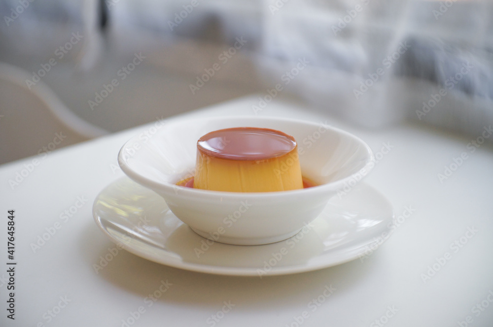 Pudding caramel custard in White ceramic bowl on table.