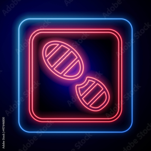 Glowing neon Human footprints shoes icon isolated on black background. Shoes sole. Vector.