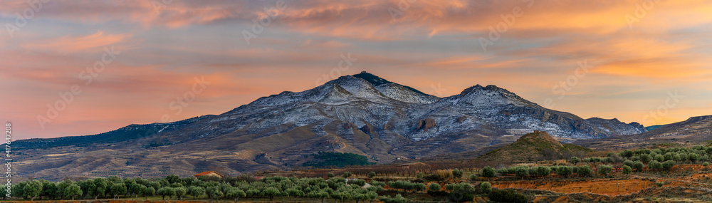 valley and peak of snow-capped mountain at sunset, hairy colors of the sunset.