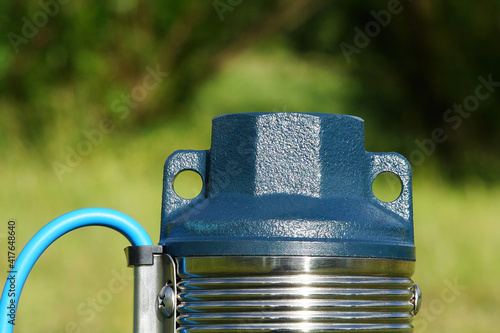 Downhole pump close-up on a bright background. Well pump with blue cable. The top of the well pump.