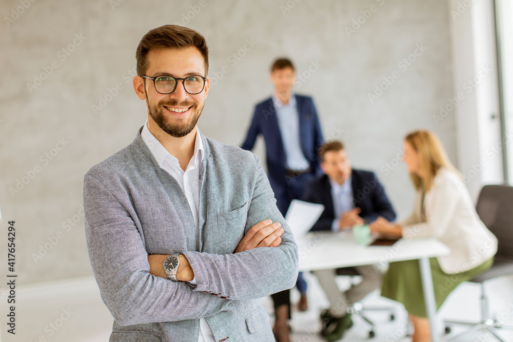 Fototapeta premium Handsome young business man standing confident in the office