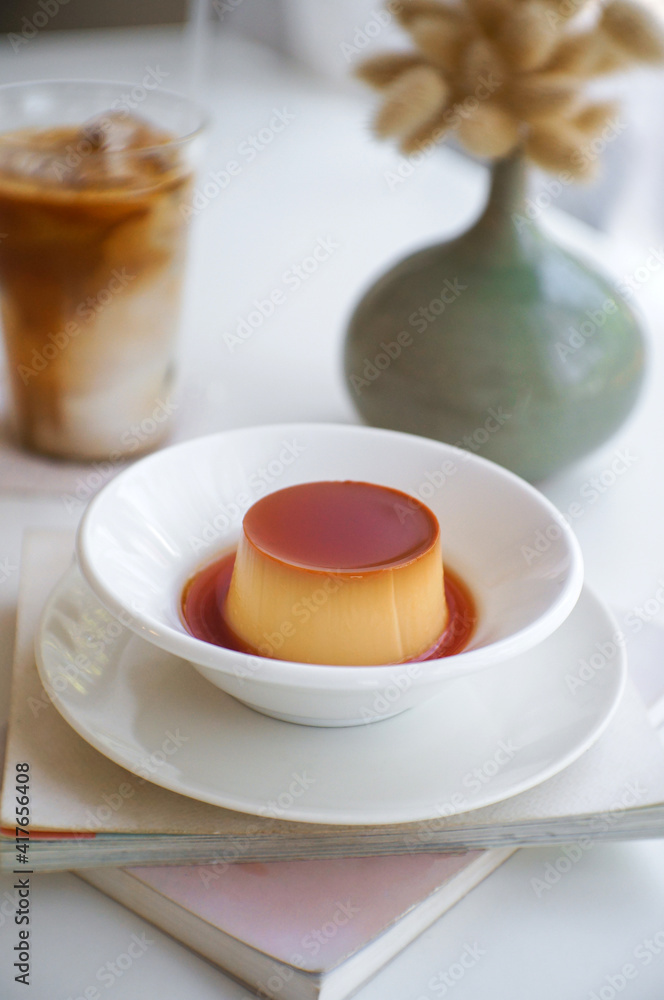 Homemade caramel custard pudding in a ceramic plate, deer on the book. Homemade caramel custard pudding in a ceramic plate, deer on the book.