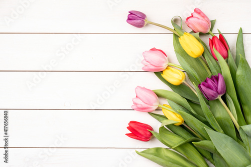 Red and pink tulips white wooden background top view flat lay