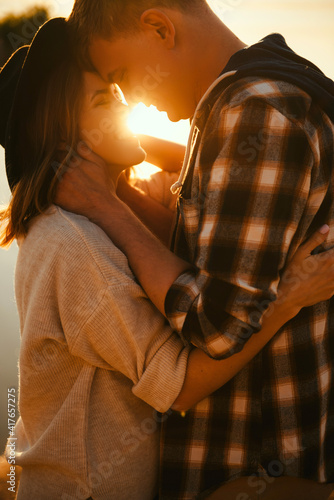 Cheerful couple hugging during summer sunset outdoors