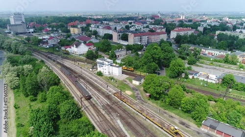 The old passenger train travels on rails in the suburbs of the city. In the distance, city buildings on a video from a drone.
