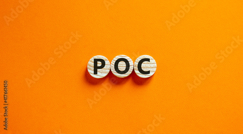 POC, people of color symbol. Wooden circles with the word POC, people of color. Beautiful orange background. Business and POC, people of color concept, copy space.