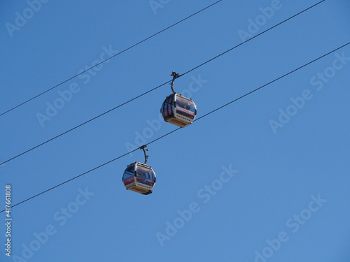 two cable cars against a cloudless blue sky in London near Greenwich