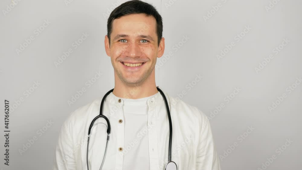 A young handsome doctor takes off his medical protective mask and sighs heavily. A young handsome doctor takes off his medical protective mask and sighs heavily.