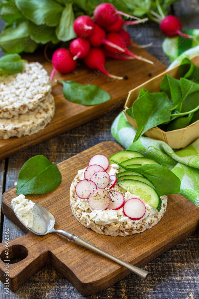 Healthy breakfast. Crunchy crispbread Sandwiches with ricotta, radish and fresh cucumber on a wooden table. Healthy breakfast. Crunchy crispbread Sandwiches with ricotta, radish and fresh cucumber on a wooden table.