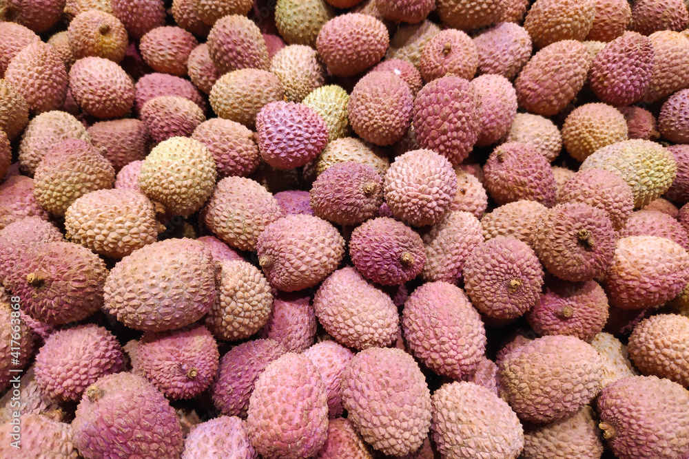 Close-up on a stack of Lychees on a market stall.