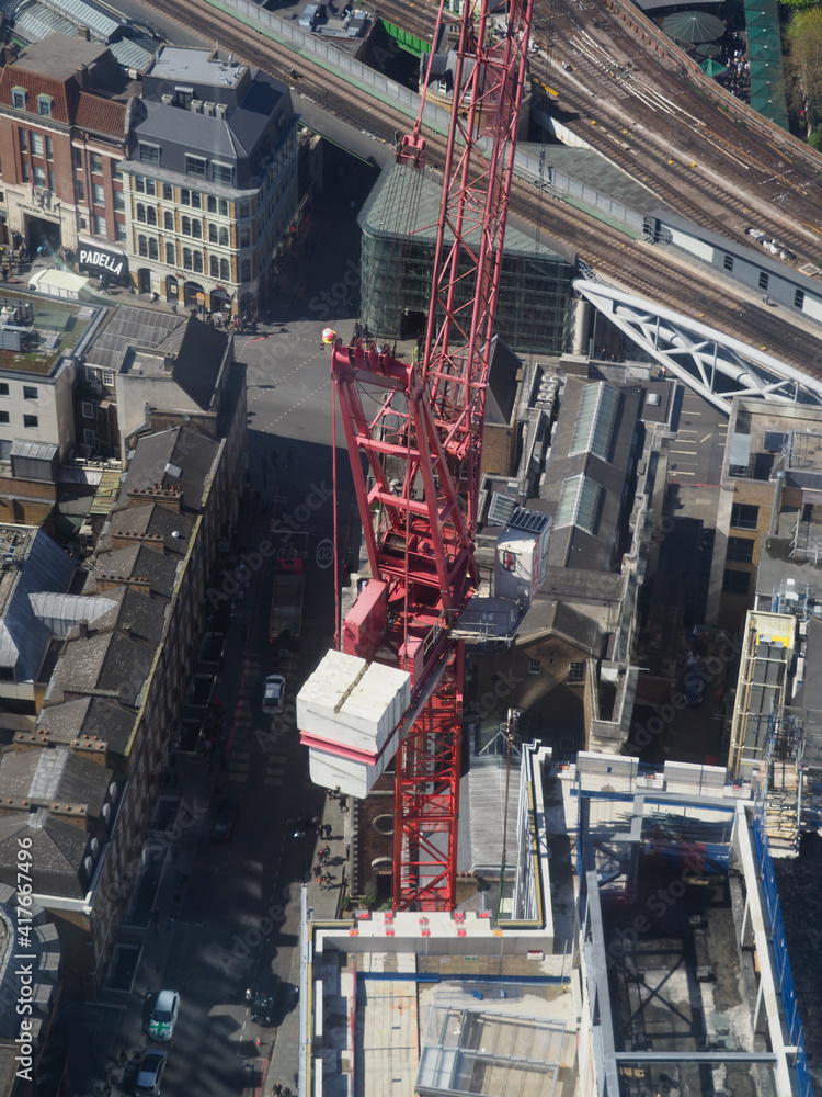 Naklejka premium aerial view of a tall building seen from above showing tower crane 