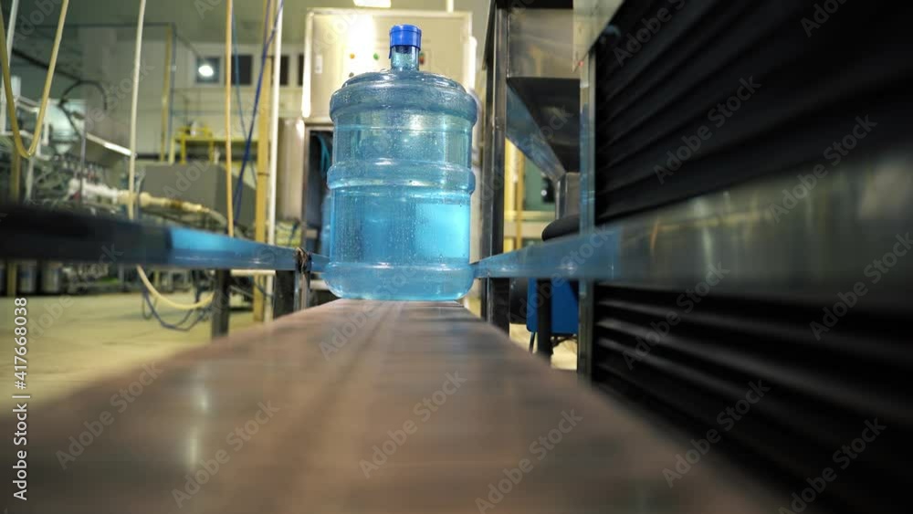 New plastic bottles on a conveyor belt at a drinking water factory. New plastic bottles on a conveyor belt at a drinking water factory.