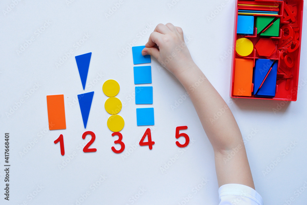 The child learns Number line and geometric shapes. The preschooler works with Montessori material. Educational logic toys for kid's. Children's hands close-up. Montessori Games for Child Development. The child learns Number line and geometric shapes. The preschooler works with Montessori material. Educational logic toys for kid's. Children's hands close-up. Montessori Games for Child Development.