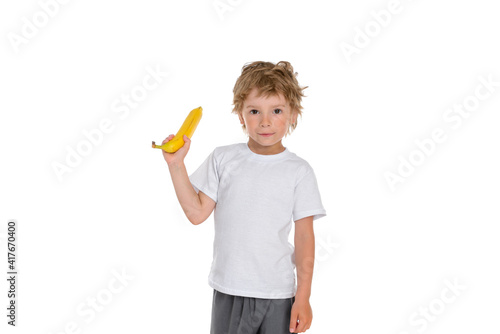 A boy with a banana in his hand looks with a serious look