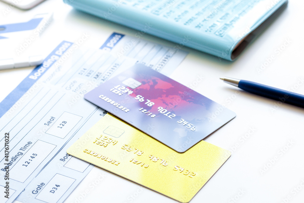 Buying airline tickets online with credit cards on table background